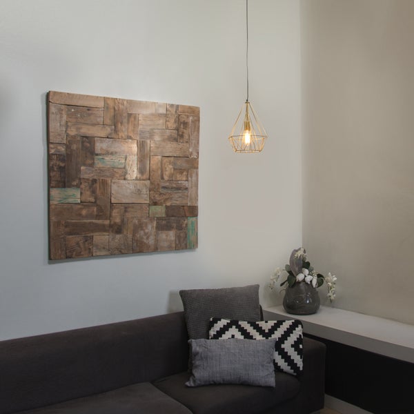 Wohnzimmer mit Sofa, Holzwandbild und geometrischer Pendelleuchte.