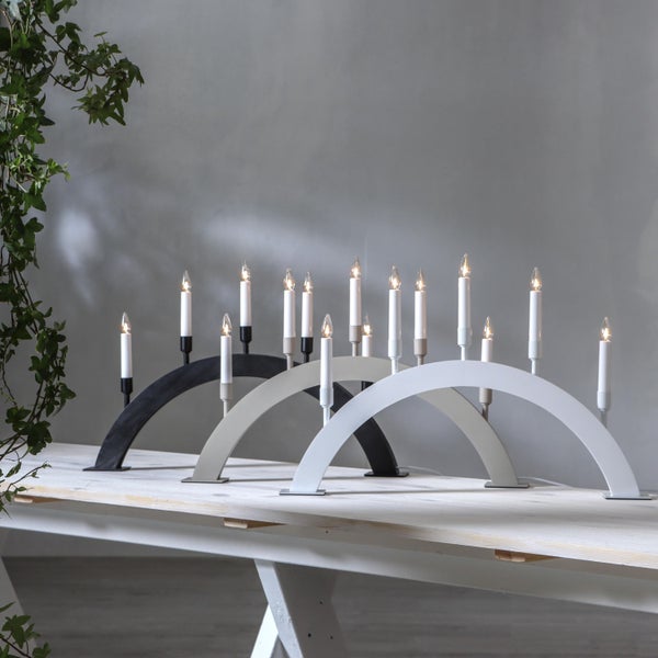 Drei Bogenleuchter mit Kerzen auf einem Tisch