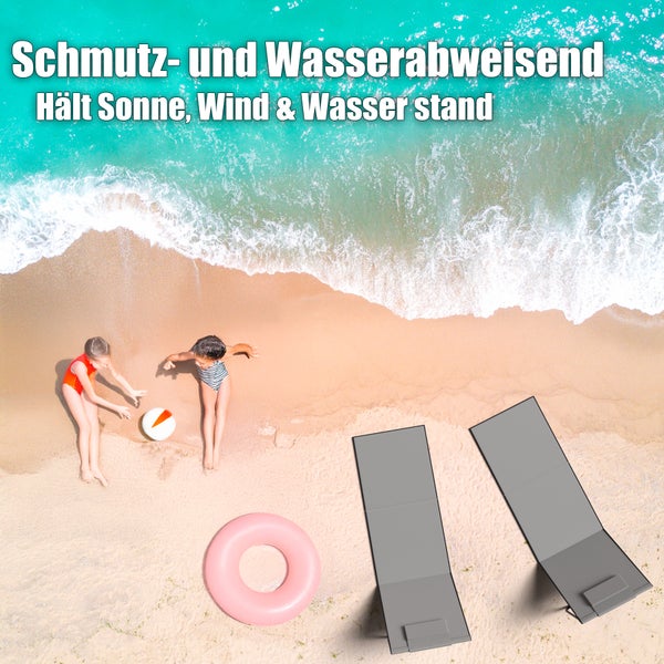 Strand mit zwei Kindern, einem rosa Schwimmring und zwei grauen Strandmatten