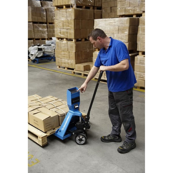 Ein Arbeiter bedient einen blauen Handhubwagen mit integrierter Waage in einem Lagerhaus.