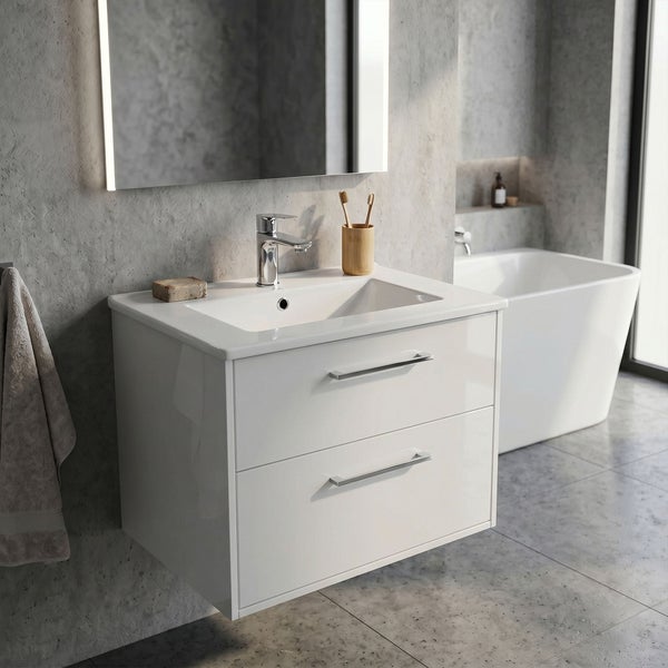 Moderner weißer Waschbeckenunterschrank mit zwei Schubladen und integriertem Waschbecken in einem hellen Badezimmer mit Wänden in Betonoptik.