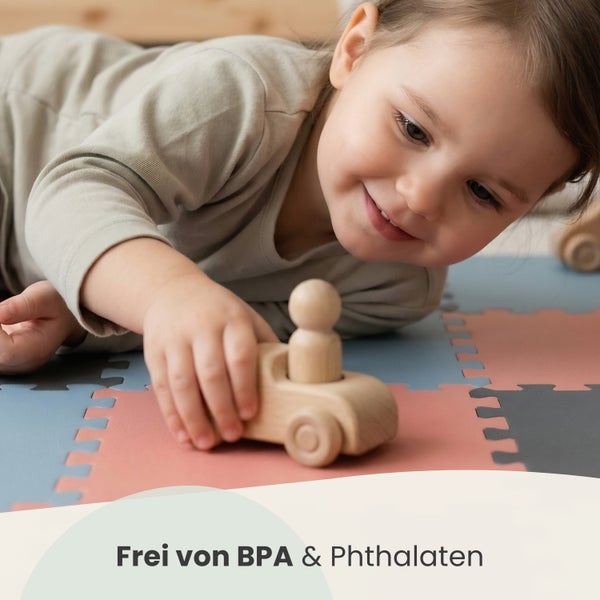 Kleinkind spielt mit einem Holzauto auf einer Puzzlematte aus Schaumstoff, frei von Bisphenol A und Phthalaten.