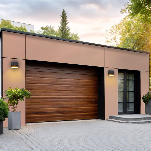 Moderne Garage mit Holzsektionaltor, Außenbeleuchtung und gepflasterter Zufahrt