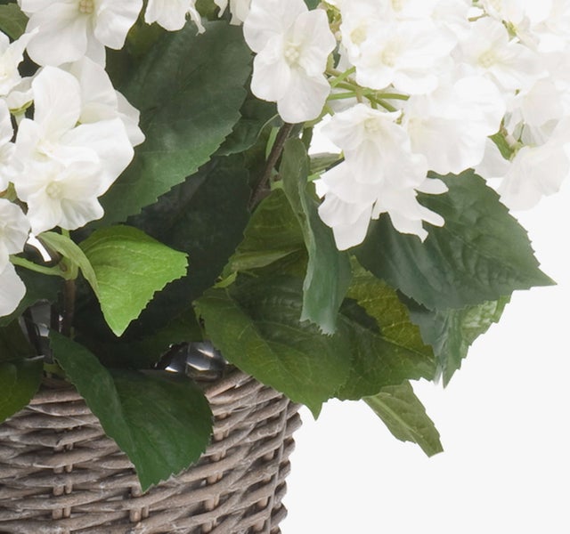 Künstliche pinke Blume mit grünen Blättern und grünem Stiel.