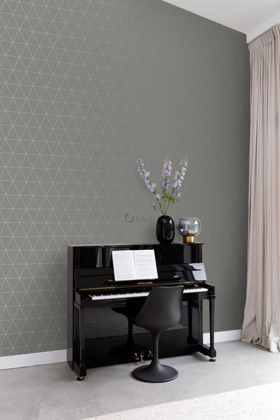 Wohnraum mit grauer Tapete mit Dreiecksmuster, einem Klavier und einer Vase mit Blumen