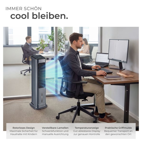 Ein moderner, rotorloser Turmventilator in einem hellen Büro. Ein Mann arbeitet am Schreibtisch, während das Gerät kühle Luft verströmt.