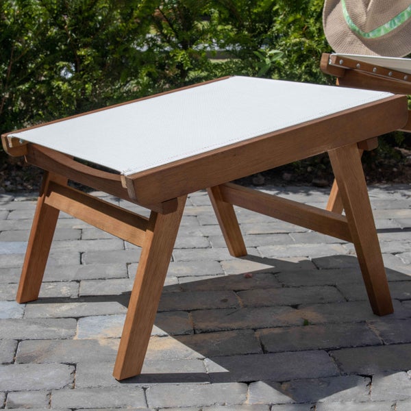 Gartenhocker aus Holz mit Textilbespannung auf einer Terrasse aus Stein.