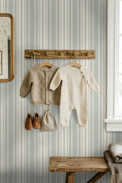 Vliestapete mit vertikalem Streifenmuster in einem Kinderzimmer mit Holzgarderobe und Kleidung