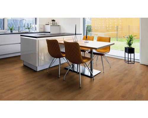 Heller Raum mit Holzboden, Esstisch und moderner Küche