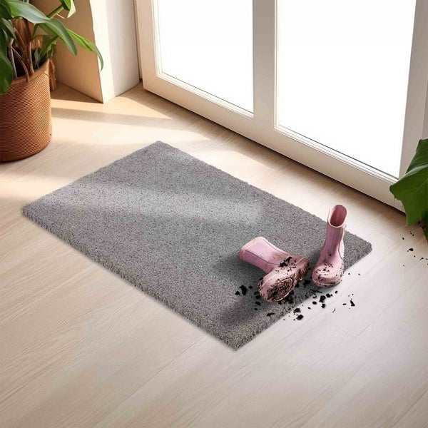 Graue Fußmatte mit pinken Gummistiefeln vor einer Terrassentür