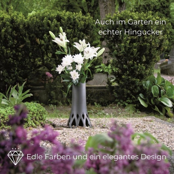 Blumenvase mit Blumen auf einem Grab