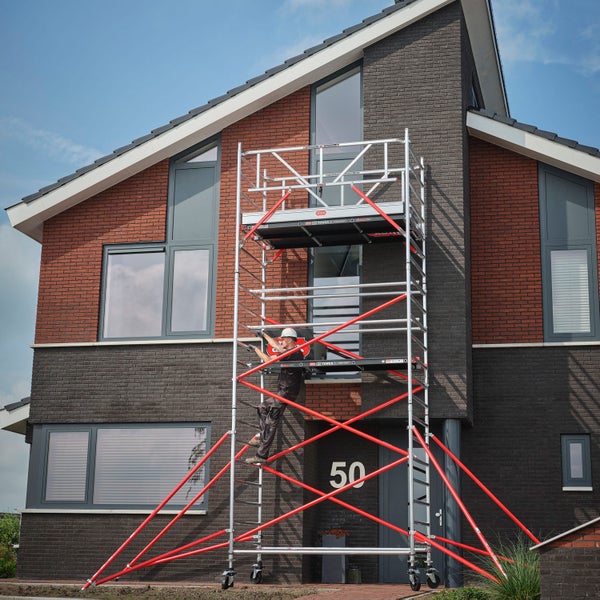 Aluminiumfahrgerüst vor einem Haus mit einem Arbeiter