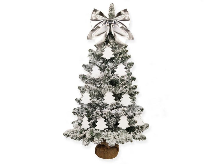Künstlicher, beschneiter Weihnachtsbaum im Jutesack, geschmückt mit Tannenbaumanhängern und einer großen Schleife als Baumspitze.