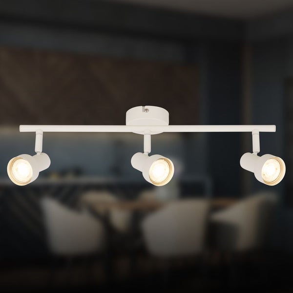 Weiße dreiflammige Deckenleuchte mit verstellbaren Spots an einer Schiene in einem modernen Raum.