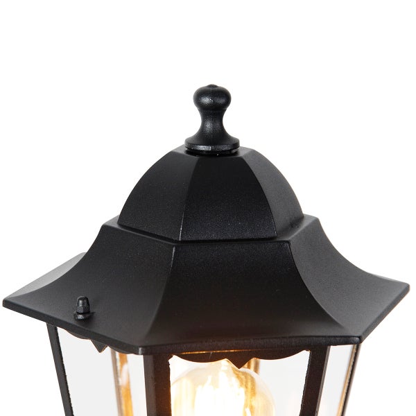Detailansicht der Oberseite einer schwarzen Außenwandleuchte in Laternenform mit dekorativer Spitze und Glaseinsätzen.
