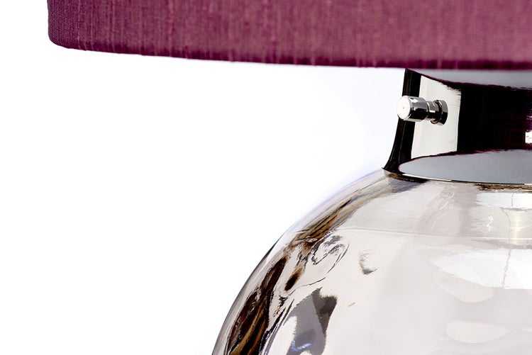 Nahaufnahme einer Tischleuchte mit Stoffschirm und einem Korpus aus Glas