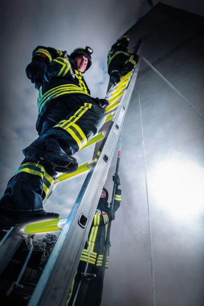 Feuerwehrleute steigen auf einer Leiter auf.