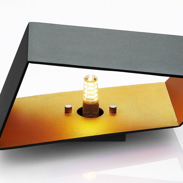 Moderne Wandleuchte aus Metall in Schwarz mit goldfarbener Innenseite und sichtbarem Leuchtmittel.