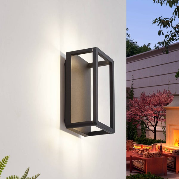 Moderne LED-Außenwandleuchte in rechteckigem Design aus dunklem Metall an einer weißen Wand im Garten montiert.