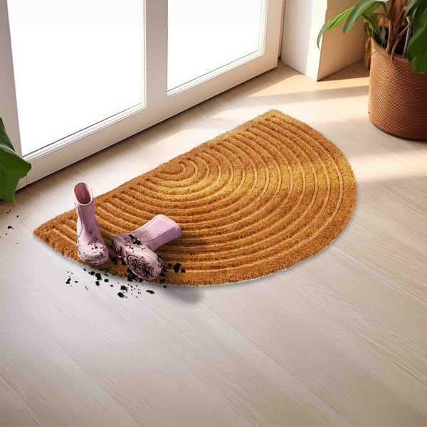 Halbrunde Fußmatte aus Kokosfasern vor einer Tür mit Gummistiefeln