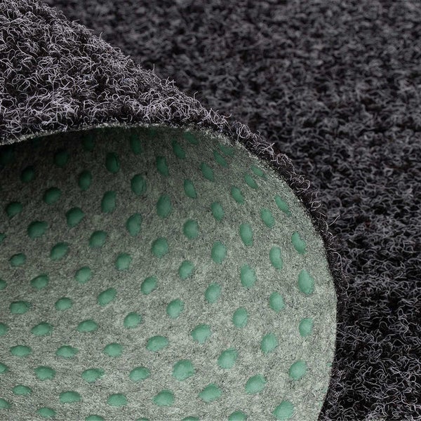 Detailaufnahme eines Teppichs mit strukturierter Oberfläche und rutschfester Unterseite mit Noppen.