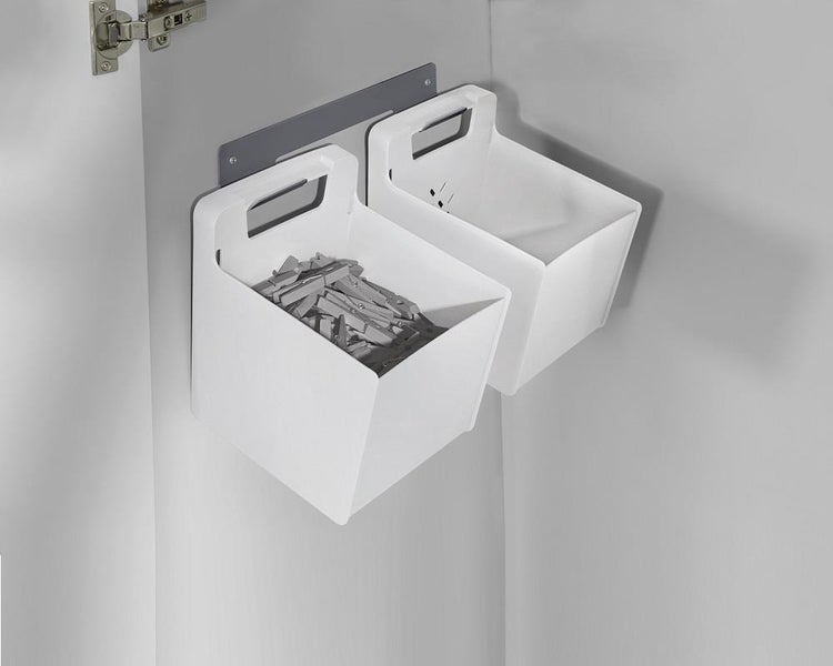 Zwei weiße Aufbewahrungsboxen aus Kunststoff an einer Wandschiene, eine Box mit hölzernen Wäscheklammern befüllt.