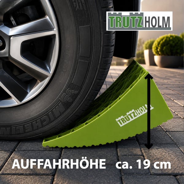 Trutzholm Auffahrkeil mit 19 Zentimeter Auffahrhöhe für Wohnwagen und Reisemobile vor einem Autoreifen.