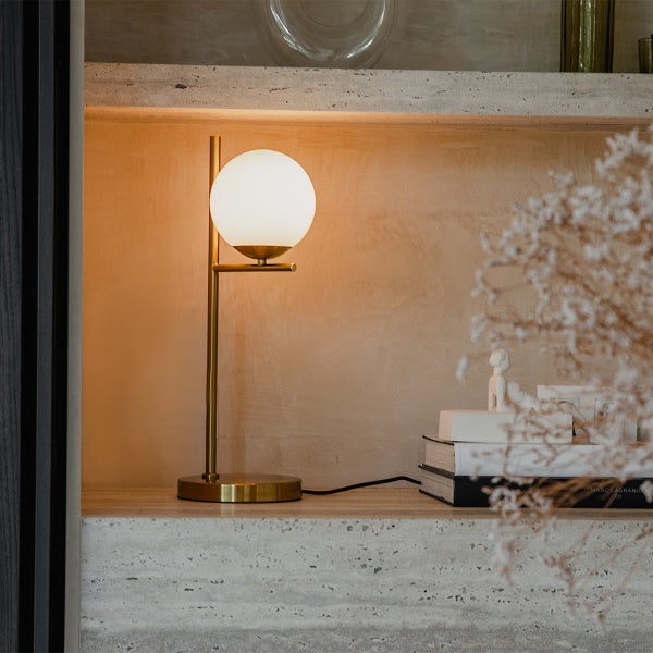 Tischleuchte mit runder Lampe auf einem Regal