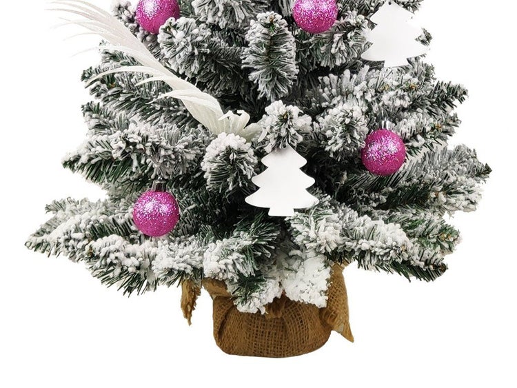 Künstlicher Mini-Weihnachtsbaum mit Schnee-Effekt, geschmückt mit Kugeln, Anhängern und Feder, in einem Jutesack stehend.