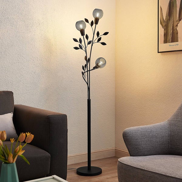 Dekorative Stehlampe in Schwarz mit Blätterdesign und drei Lichtpunkten im Wohnzimmer.