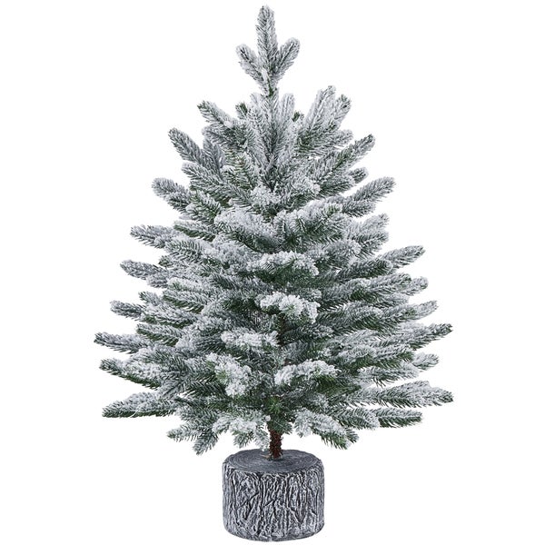 Künstlicher Weihnachtsbaum mit Schnee auf Baumstamm