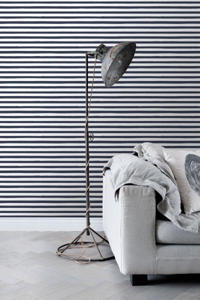 Innenraum mit gestreifter Tapete, Stehlampe und Sofa