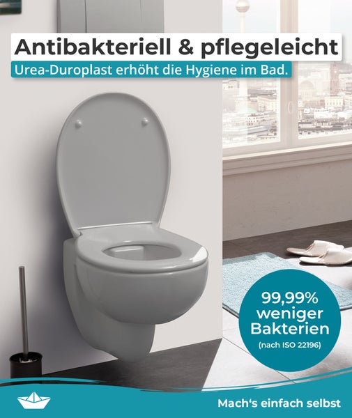 Wand-WC aus antibakteriellem Urea-Duroplast mit hochgeklapptem Deckel in einem Badezimmer.