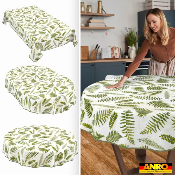Abwaschbare Tischdecke mit Farn-Muster in eckiger, ovaler und runder Form auf einem Holztisch in einer hellen Küche. ANRO DEUTSCHE MANUFAKTUR Logo.