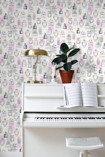 Dekorative Tapete mit Parfümflakonmuster hinter einem weißen Klavier und einer goldenen Lampe.