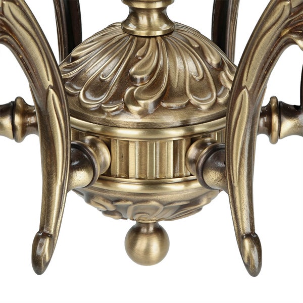 Detailaufnahme einer dekorativen, messingfarbenen Leuchte mit floralen Ornamenten