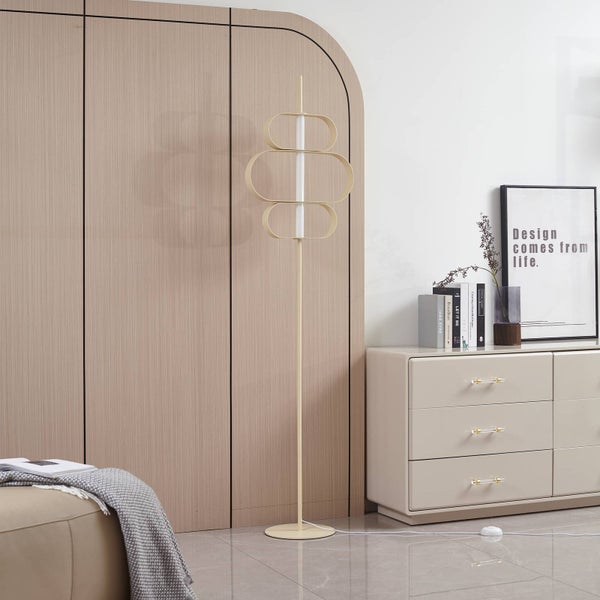 Moderne LED-Stehleuchte mit geometrischen ovalen Formen in einem hellen Raum neben einer beigen Kommode und einer Holzwand.