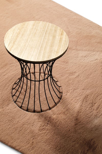 Moderner Beistelltisch mit runder Holzplatte und Drahtgestell aus Metall auf einem weichen Hochflor-Teppich.