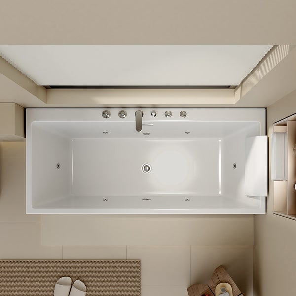 Draufsicht auf eine rechteckige Whirlpool-Badewanne mit verchromten Armaturen, Massagedüsen und einer weißen Nackenstütze in einem hellen Badezimmer.