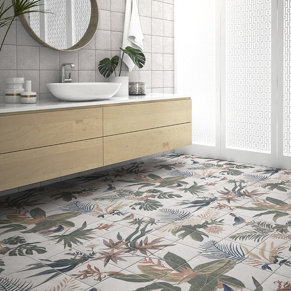Modernes Badezimmer mit holzfarbenem Waschtisch, Aufsatzwaschbecken und Bodenfliesen mit floralem Muster in einem hellen und stilvollen Raum.