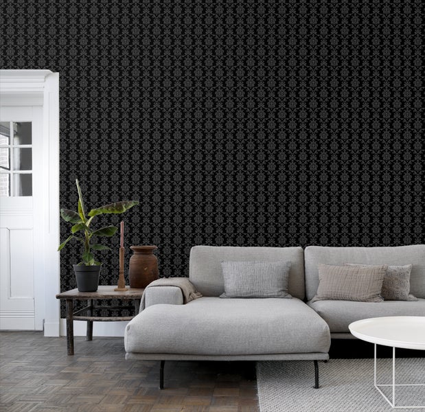 Wohnzimmer mit schwarzer Mustertapete, Sofa und Holzboden