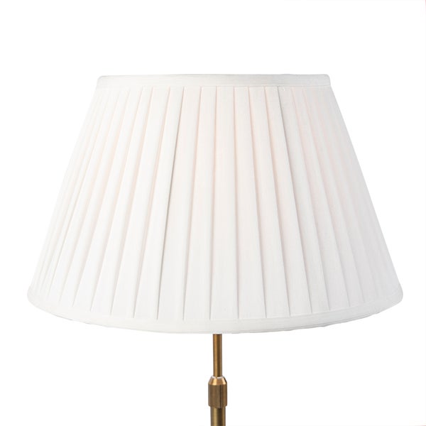 Weißer plissierter Lampenschirm aus Stoff, konische Form, auf einem goldfarbenen Metallständer.