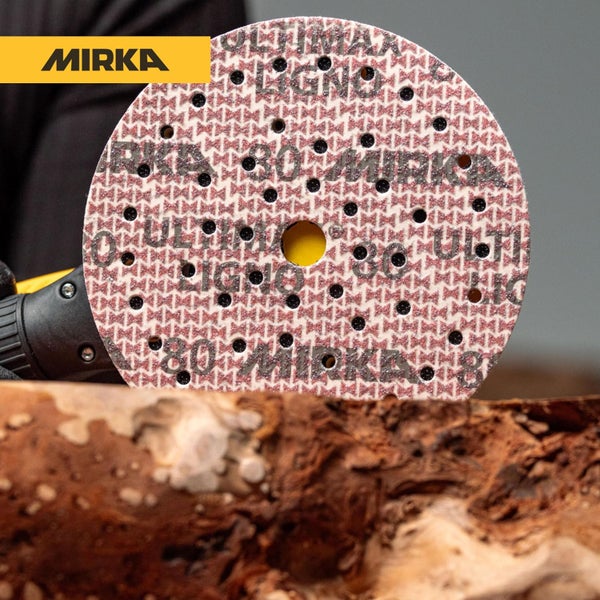 Mirka Logo und runde Schleifscheibe mit Lochmuster auf einem Holzblock