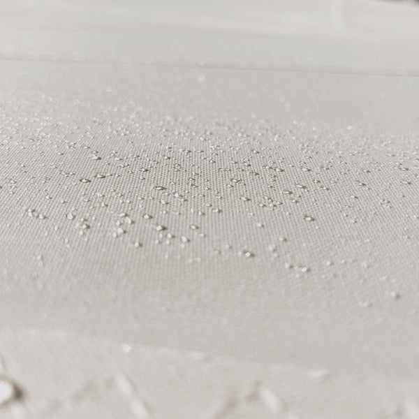 Nahaufnahme eines wasserabweisenden Gewebes mit Wassertropfen auf der Oberfläche.