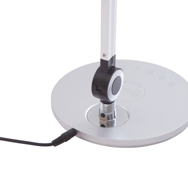 Nahaufnahme des runden Fußes einer silbernen Schreibtischlampe mit Netzkabel, Gelenk und Touch-Steuerung.