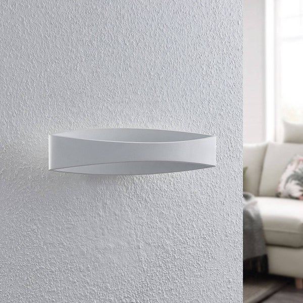 Moderne, ovale Wandleuchte in minimalistischem Design an einer strukturierten Wand in einem hellen Wohnzimmer.
