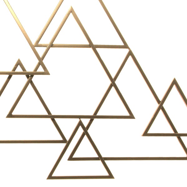 Wanddekoration aus Metall mit überlappenden Dreiecken im geometrischen Stil.