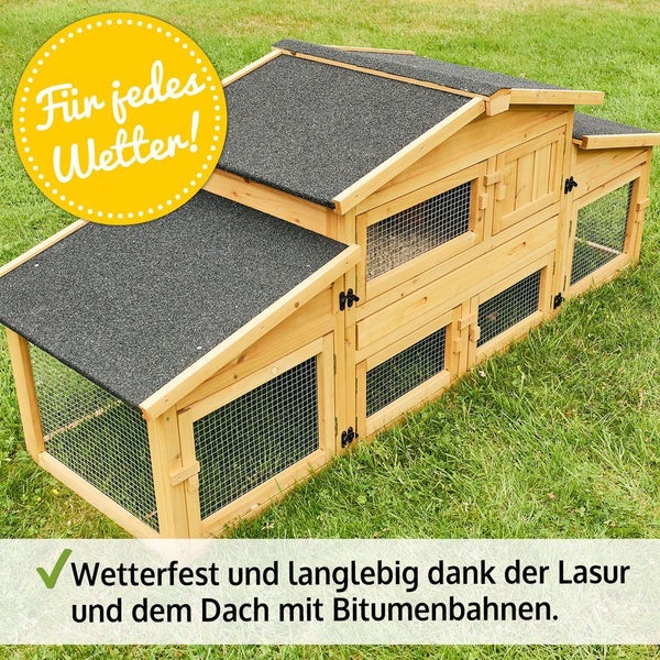 Mehrstöckiger, wetterfester Kleintierstall aus lasiertem Holz mit Bitumendach auf einer Rasenfläche.