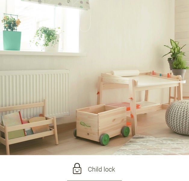 Kinderzimmer mit Kindermöbeln aus Holz: Maltisch, Spielzeugkiste auf Rädern und Bücherregal.