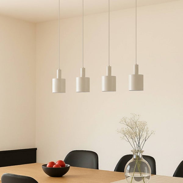 Vier weiße Pendelleuchten über einem Esstisch